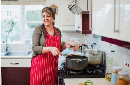 A caregiver cooking a meal in a home kitchen