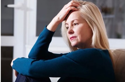 A woman resting on a couch taking a break from caregiving