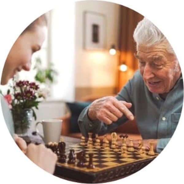 A caregiver playing chess with an older man