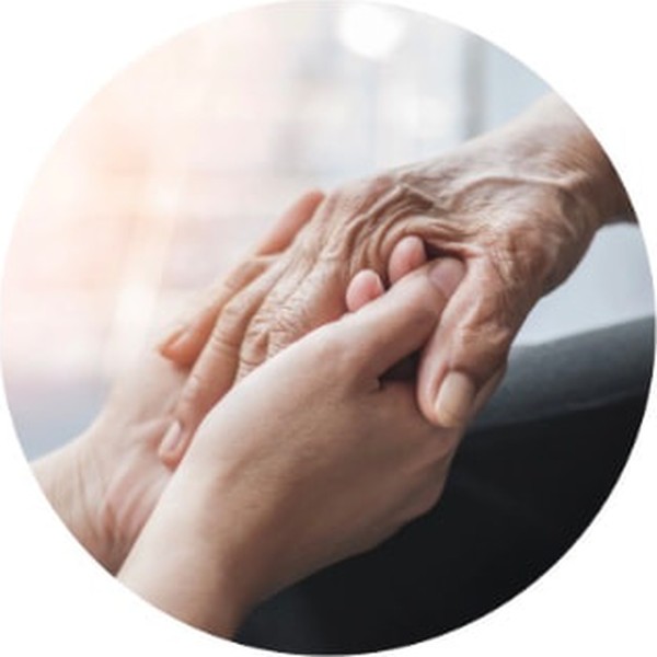 Hands gently holding the hands of an elderly person