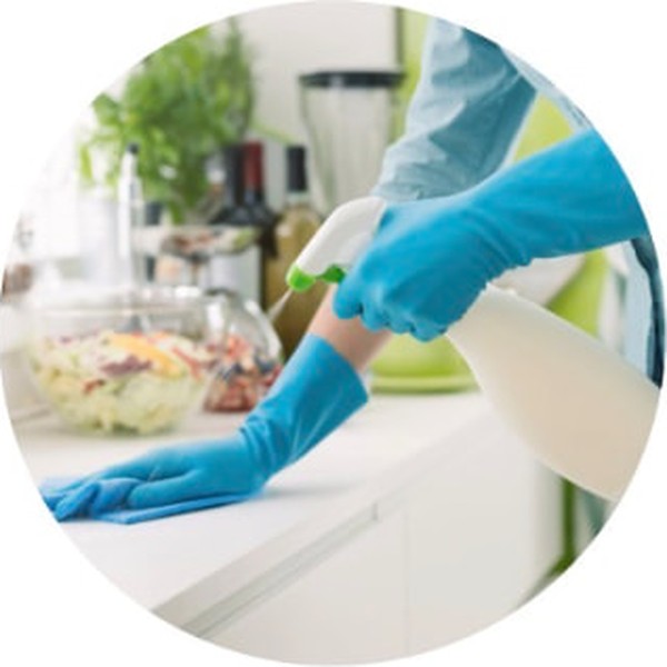 Gloved hands wiping down a kitchen counter